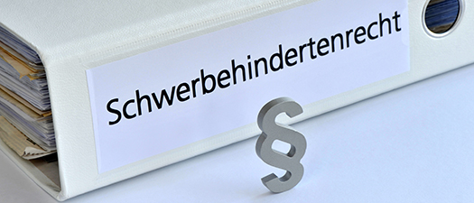 Symbolbild: Schriftzug Schwerbehindertenrecht auf einem Ordner und ein Paragraphenzeichen