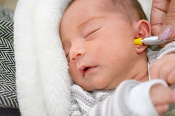 Symbolbild: Ein Neugeborenes wird mit der Hörscreening Methode untersucht