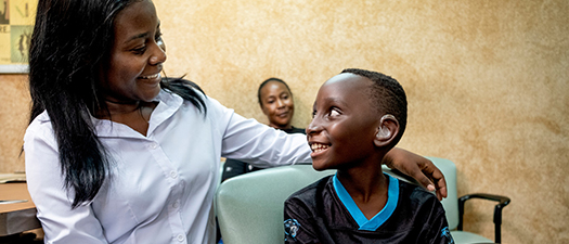 Bildbeschreibung: Der kleine Junge Kaysha bekommt von der Hörakustikerin Precious Mumba sein Hörgerät angepasst.
