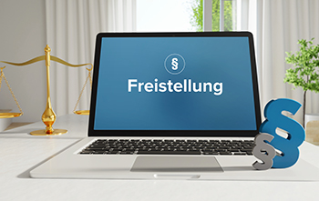 Auf dem Foto ist ein Monitor abgebildet und darauf ist ein Paragrafenzeichen sowie das Wort Freistellung zu sehen.